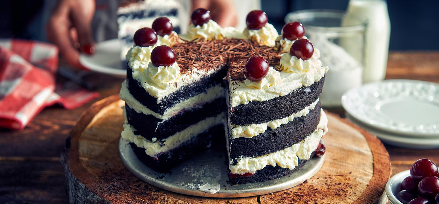 Urodzinowy tort czekoladowo-śmietankowy z wiśniami i bitą śmietaną